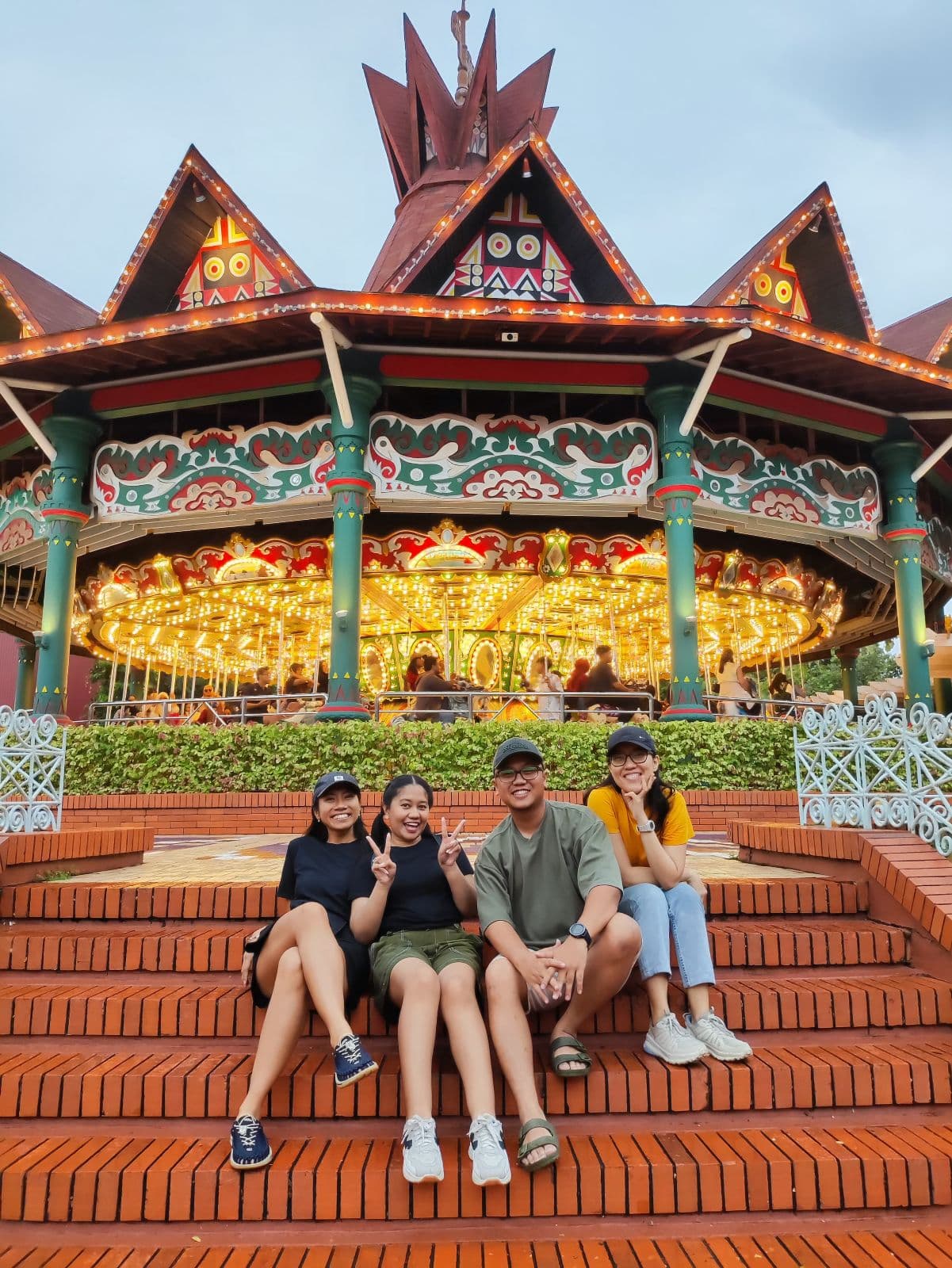Four friends sitting together on carousel steps