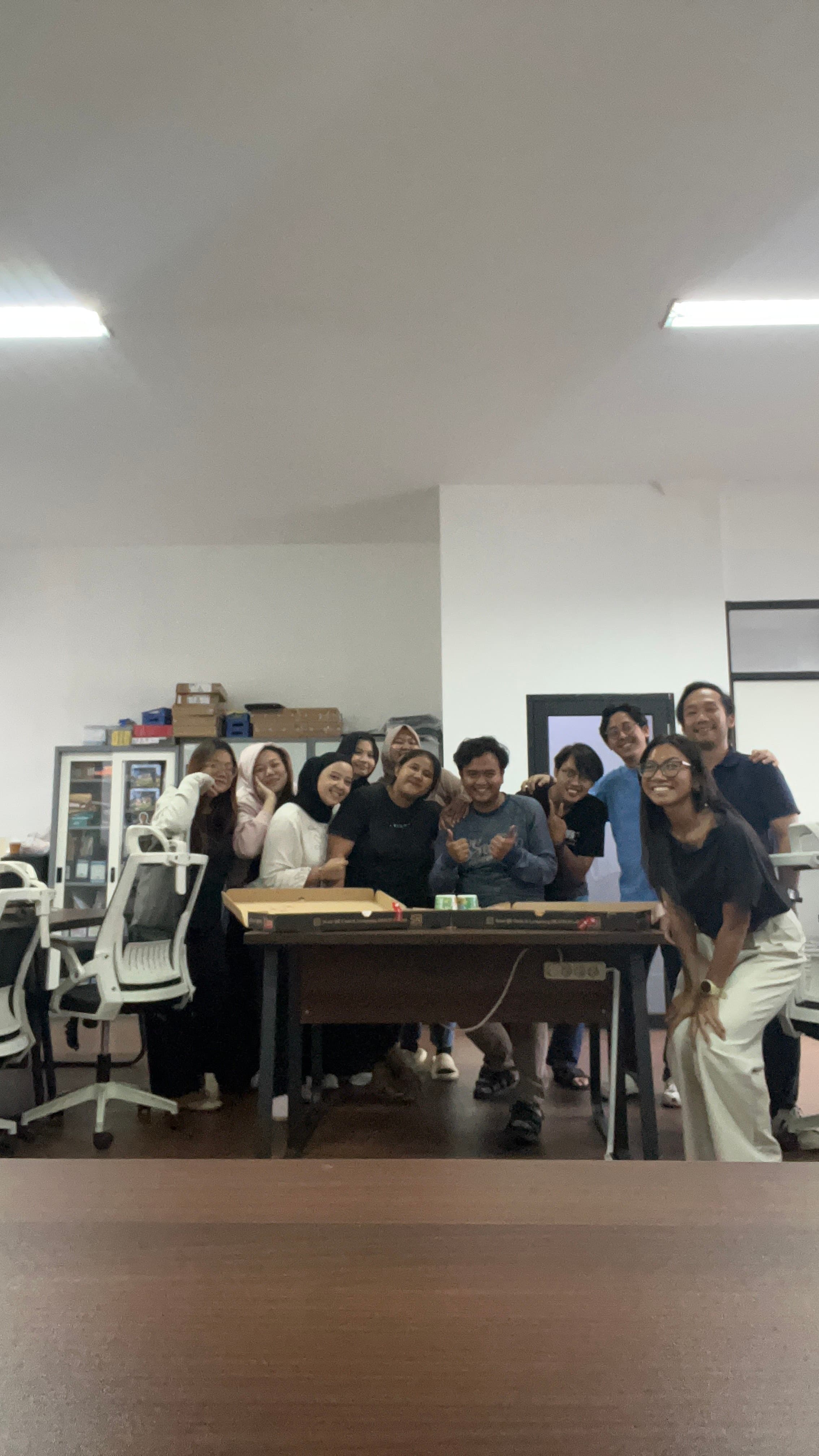 Coworkers celebrating together around pizza