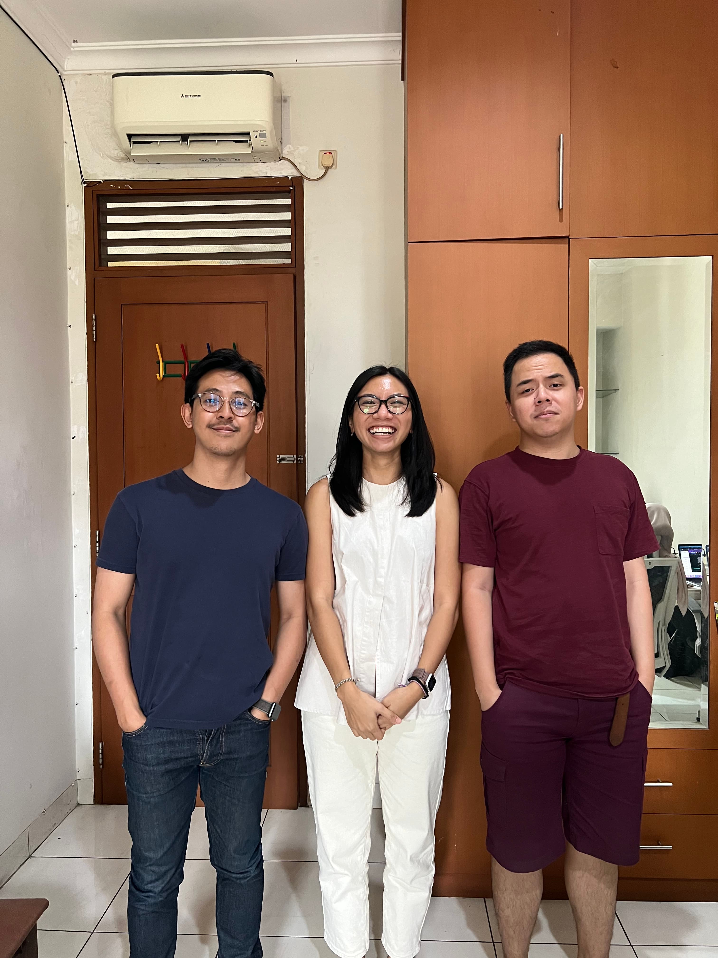 Three coworkers posing together indoors