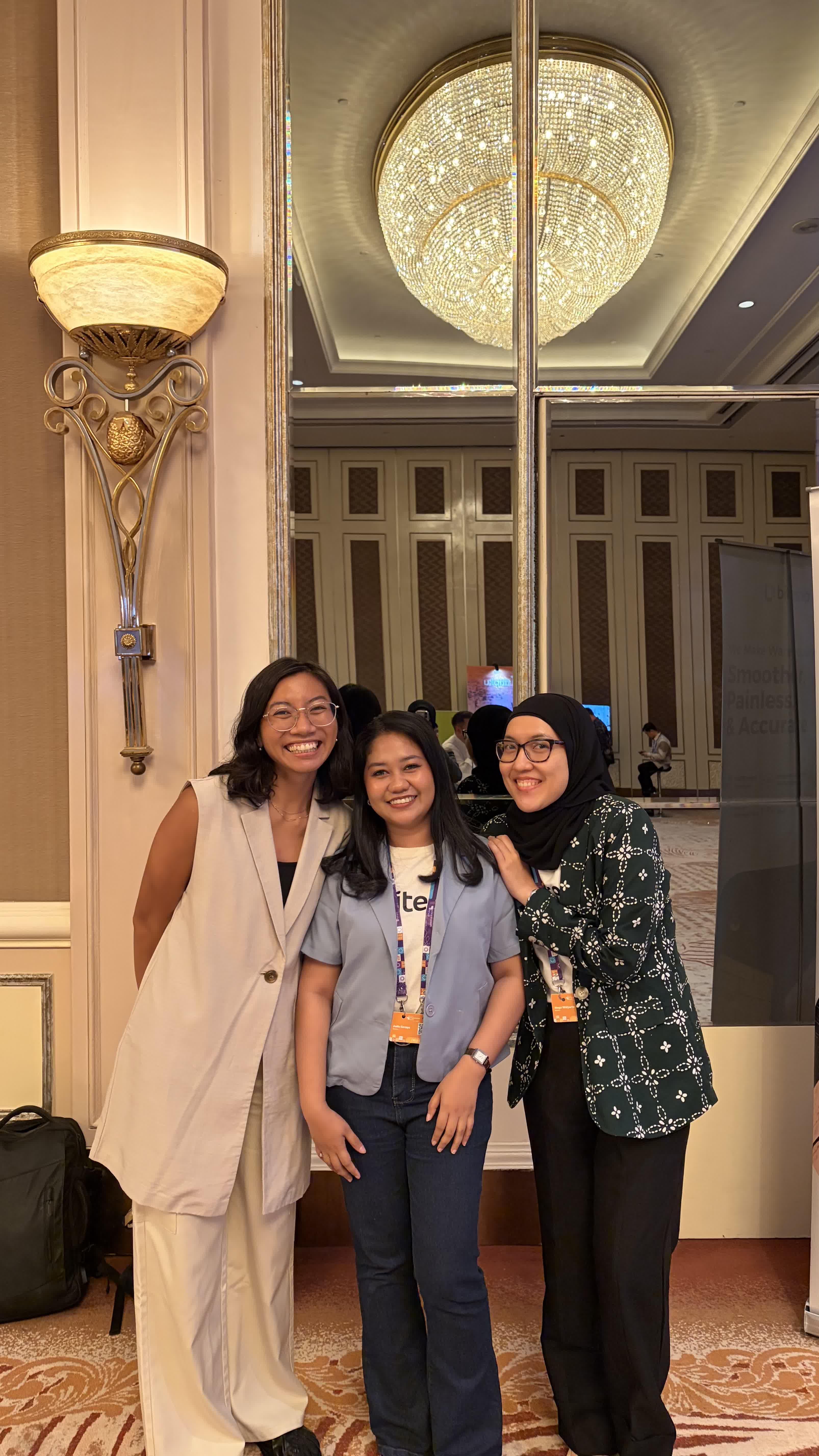 Three coworkers posing together at a conference