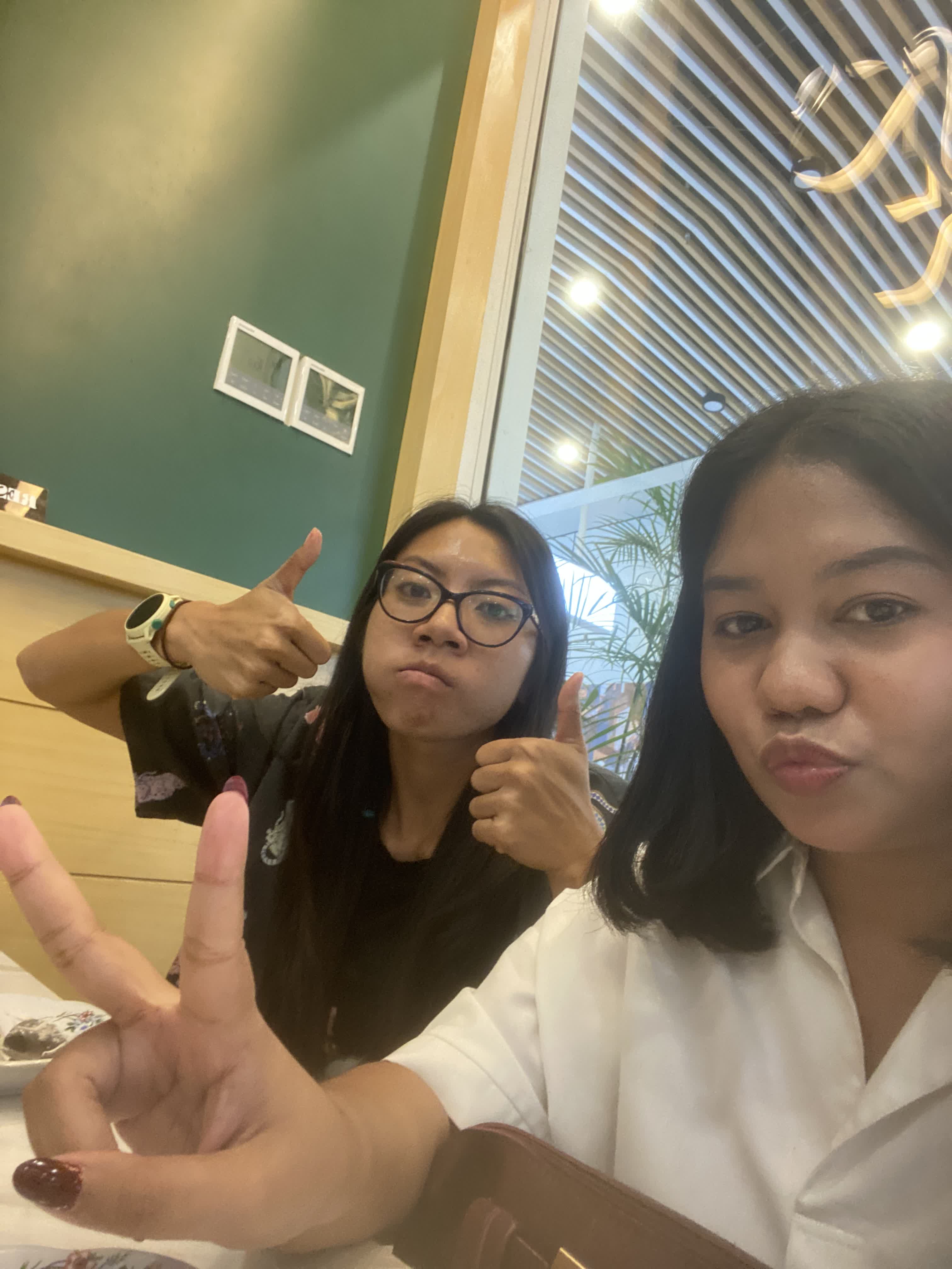 Two friends making playful gestures at a restaurant
